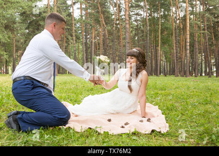 Un uomo presenta la sua sposa un bel bouquet di fiori Foto Stock