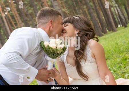 Un uomo presenta la sua sposa un bel bouquet di fiori Foto Stock