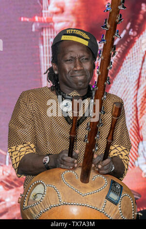 Il musicista Africab Felix Ngindu suona con la band Carloud, suonando un tamburo a corda Khim; o Kora, un liuto di arpa ad arco dell'Africa Oye del West African 21 a Sefton Park Liverpool, Regno Unito Foto Stock