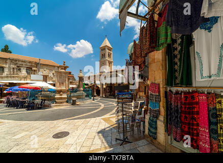 Piazzetta con fontana tra negozi di articoli da regalo come campanile sullo sfondo nel Muristan trimestre a Gerusalemme, Israele. Foto Stock