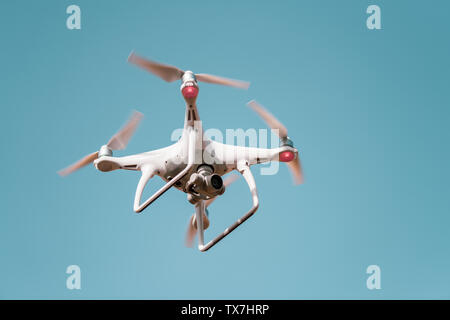 Quadrocopter drone con la telecamera contro il cielo blu. Foto Stock