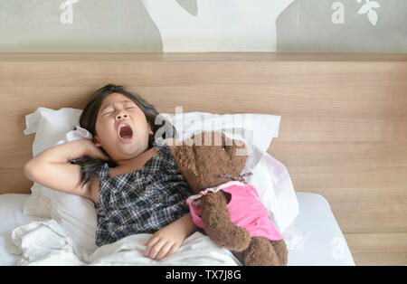 Ragazza asiatica si sveglia e stretching su letto di mattina e lo stile di vita e il concetto di sano Foto Stock