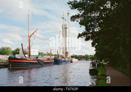 Il fiume Lea Navigazione a Tottenham Hale, Londra UK, con ormeggiate imbarcazioni da fiume e la nuova Hale Wharf in costruzione Foto Stock