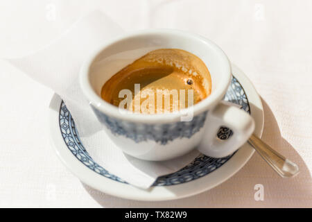 Caffè espresso italiano caffè con panna su un tavolo fuori da un bar in Italia in una giornata di sole. Foto Stock