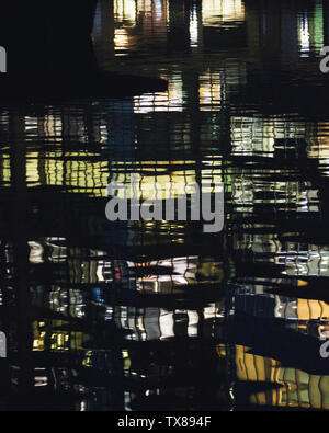 I riflessi di luce sull'acqua dagli edifici dal Dock Sud in Canary Wharf financial district. Canary Wharf, Londra, Regno Unito. Foto Stock