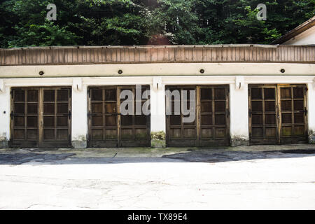 Quattro vecchie porte di garage in antico edificio grunge nella città abbandonate. Foto Stock