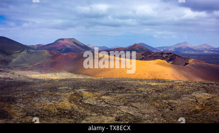 Caldera vulcanica cratere con bellissimi colori nell'isola di Lanzarote con più vulcani in background Foto Stock