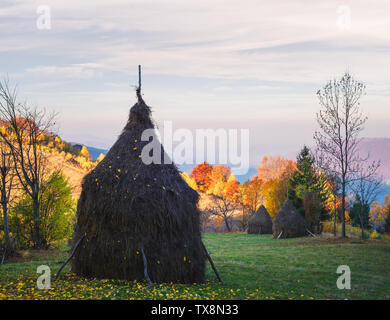 Paesaggio autunnale con un pagliaio in un villaggio di montagna. Vista sulla campagna Foto Stock