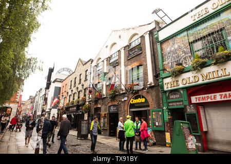 I turisti passeggiare tra i pub del quartiere di Temple Bar di Dublino in Irlanda. Foto Stock