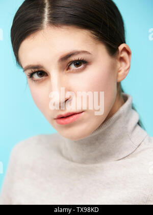 Studio ritratto di una bella donna caucasica, guardando la telecamera, isolato su sfondo blu Foto Stock