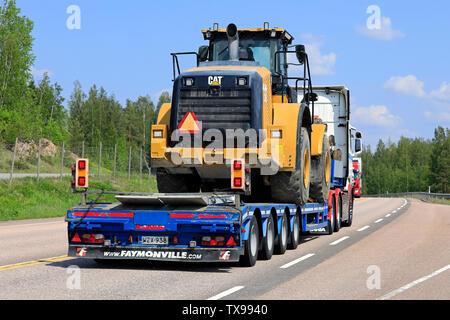 Orivesi, Finlandia. Il 6 giugno 2019. Scania R620 semi rimorchio di trasporto Pekki cale Cat caricatore su ruote in autostrada il traffico su un giorno di estate, in vista posteriore Foto Stock