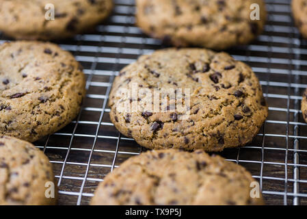 Appena sfornato biscotti al cioccolato sulla griglia di raffreddamento. Biscotti con aggiunta di dolcificanti. Dolci fatti in casa. Foto Stock