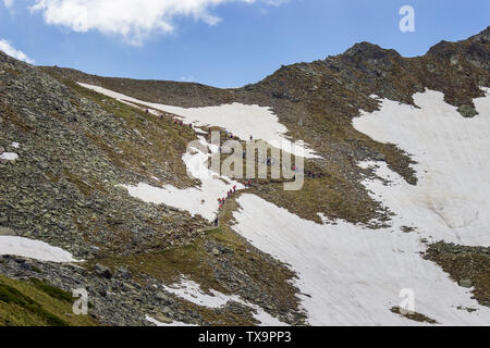 Un folto gruppo di escursionisti salendo verso il picco dei laghi sulla montagna Rila, uno dei migliori e più famosi punti di vista dei sette laghi di Rila tour Foto Stock