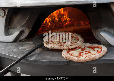 Hot pizza Margherita appena al di fuori del forno a legna. Foto Stock