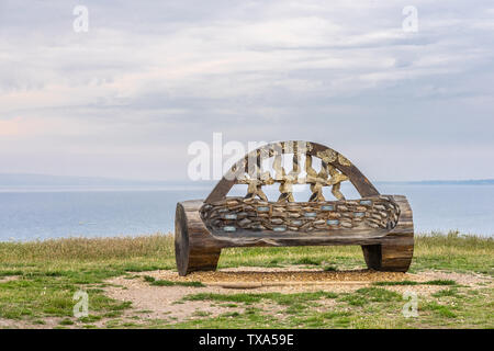 Legno scolpito memorial panca sulla cima della collina di Warren a testa Hengistbury nel Dorset, England, Regno Unito Foto Stock