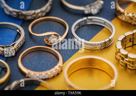 Lo sfondo da vari anelli in oro su carta colorata Foto Stock