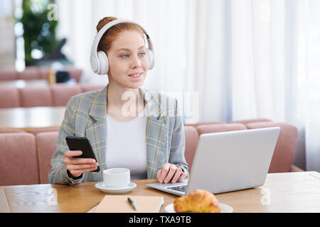 Tecnologia positivo-addicted teen girl in cuffie wireless Foto Stock