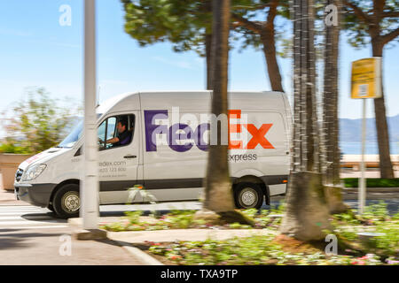 CANNES, Francia - Aprile 2019: consegna FedEx van guidando lungo la strada lungomare di Cannes e con lenta velocità otturatore utilizzato per la sfocatura movimento. Foto Stock
