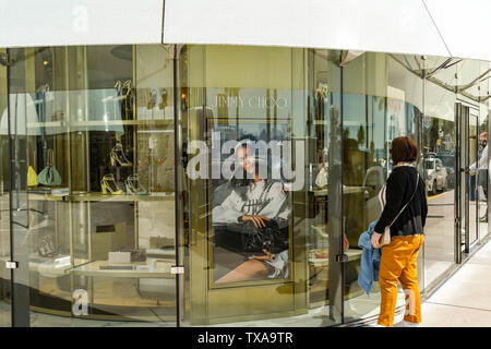 CANNES, Francia - Aprile 2019: Persona cercando nella finestra di un ramo di Jimmy Choo in Cannes sulla Costa Azzurra. Foto Stock