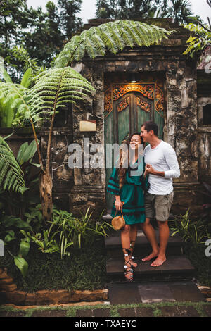 Coppia felice in amore sorridente e baciare su sfondo di tradizionale architettura balinese Foto Stock