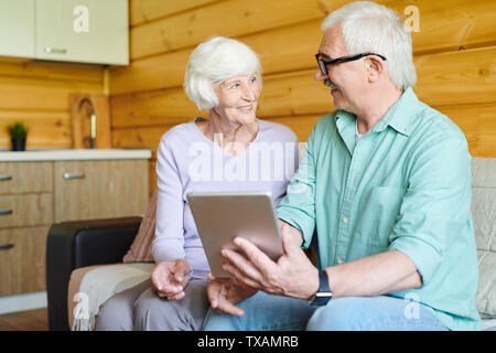 Felice coniugi senior in informale per discutere i dati online Foto Stock