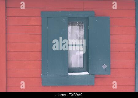 Finestra blu a metà apertura su sfondo rosso in legno Foto Stock