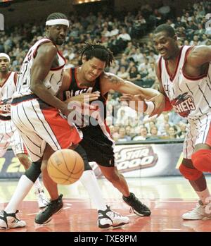 HOU2000011803 -18 Gennaio 2000 - HOUSTON, TEXAS, Stati Uniti d'America: raddoppiato le squadre, Houston Rockets, Walt Williams(L) blocchi Portland Trail Blazer Brian concessione da una sfera allentato mentre Hakeem Olajuwon guarda nella seconda metà gennaio 18. I razzi sconfitto il Trail Blazers 90-89, in Houston. gyw/George Wong UPI Foto Stock