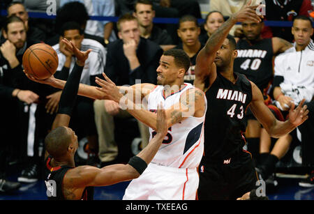 Atlanta Hawks guard Thabo Sefolosha (25) germogli intorno a Miami Heat's Shawne Williams (43) e Chris Bosh (L) durante la seconda metà del loro gioco NBA alla Philips Arena di Atlanta il 14 novembre 2014. Atlanta ha vinto 114-103. UPI/David Tulis Foto Stock