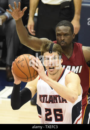 Indossare una maschera protettiva sopra il suo naso rotto, Atlanta Hawks guard Kyle Korver (26) passa ad un compagno di squadra nella parte anteriore dei Miami Heat's Luol Deng (R) durante la seconda metà di un gioco NBA alla Philips Arena di Atlanta, Marzo 27, 2015. Atlanta ha vinto 99-86. Foto di David Tulis/UPI Foto Stock