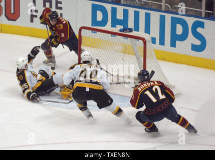 Atlanta Thrashers Marc Savard (9) Opere di ottenere il puck verso il Boston Bruins obiettivo 24 gennaio 2006, in Atlanta Philips Arena. Difesa sono Boston's branchia di Hal (25), Nick Boynton (44) e portiere Tim Thomas (nascosti da Boynton). Atlanta Peter Bondra (22), ritornando ad azione dopo 22 giochi sulla riserva di feriti, pattini nel gioco. I Bruins sconfitto il Thrashers, 3-2. (UPI foto/John Dickerson) Foto Stock