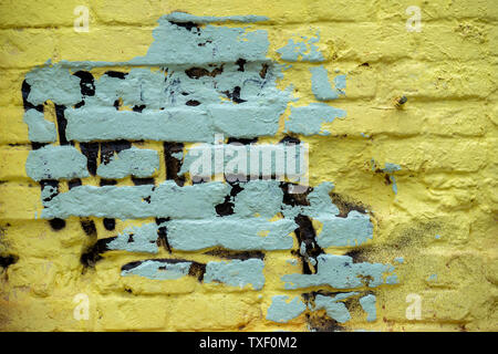 Sporchi di mattoni dipinto sulla parete danneggiata, sfondo astratto dal dipinto di giallo grigio muro di mattoni, texture, background urbano, spazio di copia Foto Stock