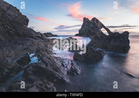 Sunrise luce e colori sulle rive del Portknockie città vicino a prua Fiddle formazione rocciosa. Highlands scozzesi, Regno Unito, Europa. Foto Stock