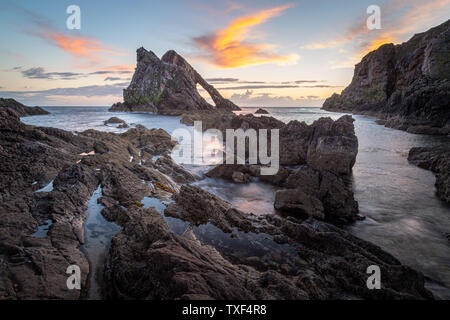 Sunrise luce e colori sulle rive del Portknockie città vicino a prua Fiddle formazione rocciosa. Highlands scozzesi, Regno Unito, Europa. Foto Stock