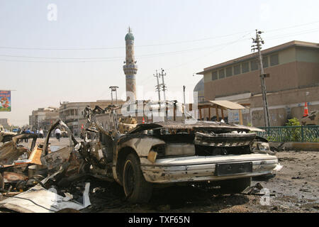 Soldati iracheni fissare la zona dove un veicolo distrutto rimane dopo attentati all'automobile intrappolata a Bagdad il 6 aprile 2009. Più di venti persone sono state uccise in quattro attentati all'automobile intrappolata in due ore, principalmente nei quartieri sciiti. (UPI foto/Ali Jasim) Foto Stock