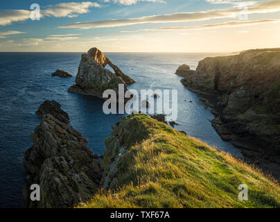 Sunrise luce e colori sulle rive del Portknockie città vicino a prua Fiddle formazione rocciosa. Highlands scozzesi, Regno Unito, Europa. Foto Stock