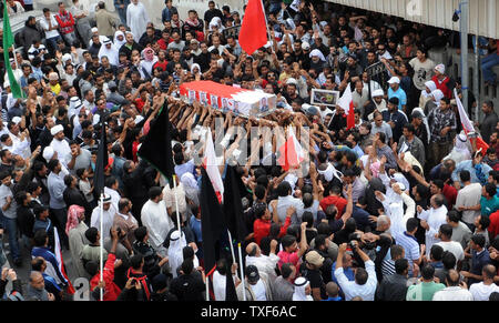 Sciita del Bahrein lutto portano la bara di 28-anno-vecchio Ahmed Farhan durante il suo funerale nella città sciita di Sitra, nella periferia di Manama, il 18 marzo 2011. Migliaia di Bahrainis riuniti per il funerale del dimostratore ucciso ore dopo che il re ha dichiarato la legge marziale in risposta ad un mese di escalation di proteste. Gli sciiti rappresentano il 70 percento della piccola isola di mezzo milione di persone ma sono ampiamente escluse dall alto livello e ai posti di polizia e militari. UPIIsa Ebrahim Foto Stock