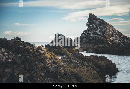 Sunrise luce e colori sulle rive del Portknockie città vicino a prua Fiddle formazione rocciosa. Highlands scozzesi, Regno Unito, Europa. Foto Stock