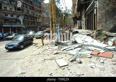 Per le strade di Beirut la periferia sud sono coperti in vetro rotto e twisted metal come alcuni dei residenti iniziare la pulizia fino a luglio 15, 2006. Decine di libanesi sono morti e le infrastrutture del paese gravemente danneggiato il quarto giorno dell'aggressione israeliana che ha cominciato il 12 luglio dopo lo Hezbollah guerrilla rapiti due soldati israeliani e ucciso altri 7. (UPI foto/Norbert Schiller) Foto Stock