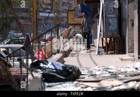 Per le strade di Beirut la periferia sud sono coperti in vetro rotto e twisted metal come alcuni dei residenti iniziare la pulizia fino a luglio 15, 2006. Decine di libanesi sono morti e le infrastrutture del paese gravemente danneggiato il quarto giorno dell'aggressione israeliana che ha cominciato il 12 luglio dopo lo Hezbollah guerrilla rapiti due soldati israeliani e ucciso altri 7. (UPI foto/Norbert Schiller) Foto Stock