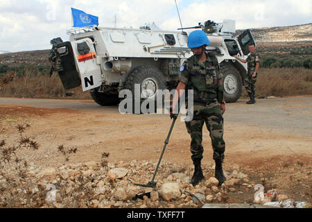 Il francese ONU di peace keeper cercare mine sul lato della strada vicino a sud villaggio libanese di Blat il 29 settembre 2006. Prima di questo ultimo conflitto tra Hezbollah e Israele, la grande preoccupazione nel sud del Libano erano le mine di terra a sinistra dietro dagli israeliani durante i loro 22 anni di occupazione del Sud che si è conclusa nel maggio 2000. Ora la nuova minaccia è il migliaia di le bombe a grappolo inesplose sparsi nelle campagne. UPI (foto) Foto Stock