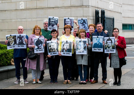 Le famiglie di coloro che sono stati uccisi durante la contestazione di un serie di tiri in Ballymurphy zona di Belfast nell' Agosto 1971 mantenere immagini dei loro cari con i sostenitori al di fuori di Belfast Laganside tribunali, durante una nuova inchiesta su i loro cari morti. Foto Stock