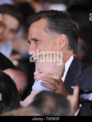 Presidenziale repubblicano speranzoso Mitt Romney tiene un bambino come egli saluta i sostenitori di un election night party su Marzo 20, 2012 a Schaumburg, Illinois. Romney ha sconfitto Rick Santorum, Newt Gingrich e Ron Paul per vincere l'Illinois primario repubblicano. UPI/Brian Kersey Foto Stock