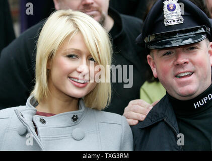 Paris Hilton si ferma per una foto con una università di Harvard funzionario di polizia dopo che essa è stata presentata con la Harvard Lampoon Donna del premio di anno presso la Harvard University di Cambridge, Massachusetts il Febbraio 6, 2008. (UPI foto/Matthew Healey) Foto Stock