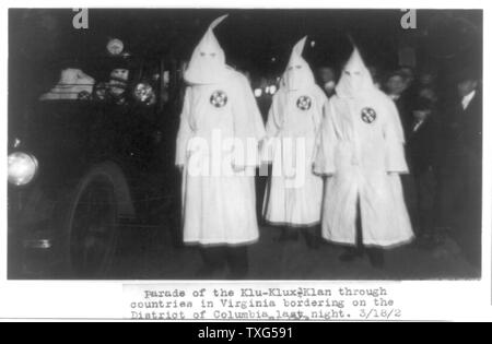 Tre membri del Ku Klux Klan in maschera e abiti di prendere parte ad un night parade Foto Stock