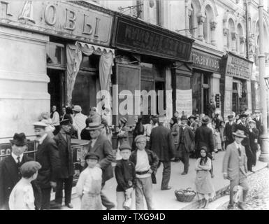 Il russo scena di strada - Febbraio 1918 donne e bambini in attesa in una lunga fila per comprare il latte. Una ragazza è la vendita di mele Foto Stock