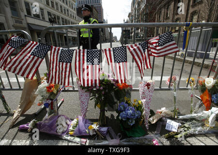 Boston ufficiali di polizia di guardia a un ripiego memorial impostato su Boylston Street a Boston, Massachusetts, il 16 aprile 2013. La sicurezza è ancora elevata in città dopo due bombe detonate su Boylston Street vicino al traguardo della Maratona di Boston lunedì pomeriggio uccidendo 3 e il ferimento di altre 150. UPI/Matthew Healey Foto Stock