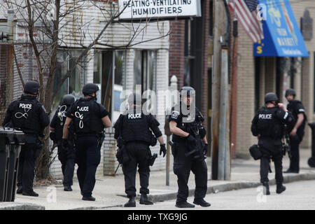 Un team SWAT cancella Bigelow Avenue durante una massiccia manhunt per uno dei due Boston Marathon bombardamento sospetti su Aprile 19, 2013. Lunedì la Maratona di Boston il bombardamento di sinistra tre morti e oltre 170 feriti. UPI/Matthew Healey Foto Stock