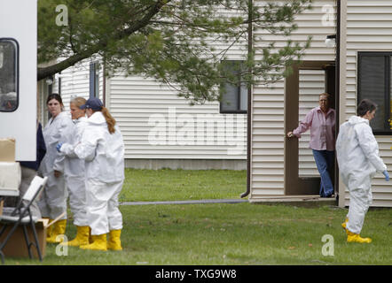 Un vicino si affaccia su come gli investigatori federale cerca l'appartamento di Dias Kadyrbayev e Azamat Tazhayako a New Bedford, Massachusetts on April 19, 2013. I due sono stati arrestati per il loro presunto coinvolgimento con la Boston Marathon bombardamenti Dzhokhar sospetto Tsarnaev. UPI/Matthew Healey Foto Stock