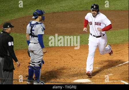 Boston Red Sox Steve Pearce (R) punteggi contro Los Angeles Dodgers catcher Austin Barnes su un doppio di J.D. Martinez durante il terzo inning di gioco uno dei MLB 2018 World Series a Fenway Park di Boston, Massachusetts, il 23 ottobre 2018. Foto di Matteo Healey/UPI Foto Stock