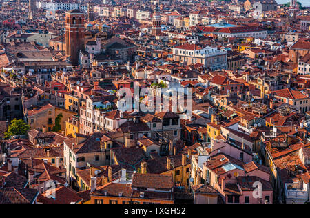 Guardando verso il basso dalla torre dell'orologio della maestosa Piazza San Marco in italiano città d'acqua di Venezia, si guardano i tetti di stile Europeo di case rosso che non può essere visto in un batter d'occhio. Foto Stock